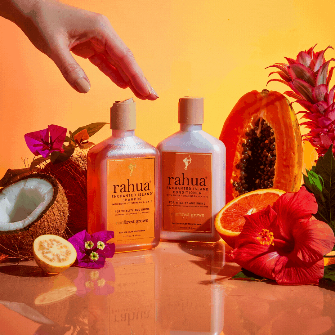 gif of model clicking open the lid of rahua enchanted island shampoo and enchanted island conditioner with fruits surrounding them guava passion fruit coconut and flowers|variant:93-oz