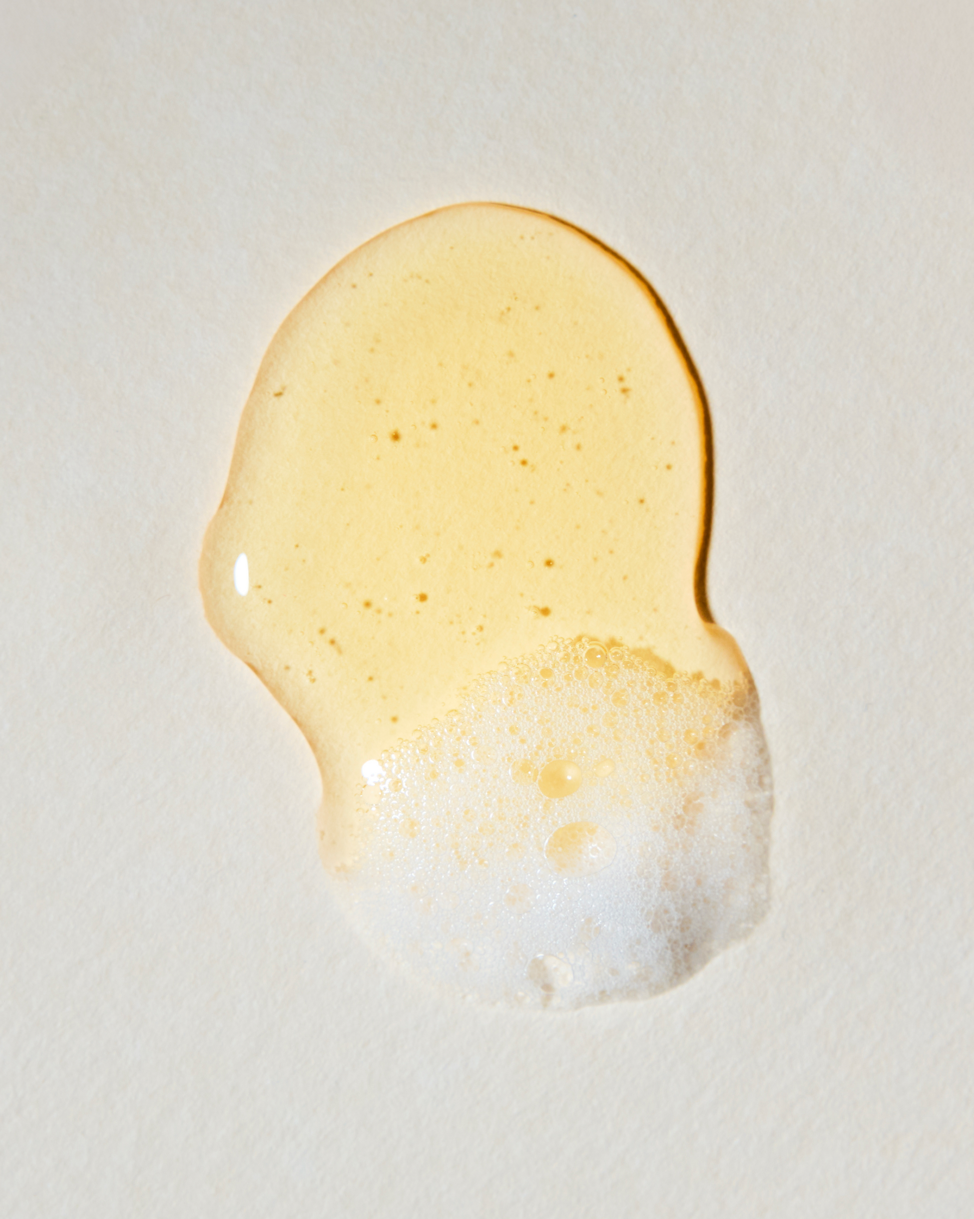 Close-up of a droplet of honey on a light background|variant:93-oz,16-oz,18-oz