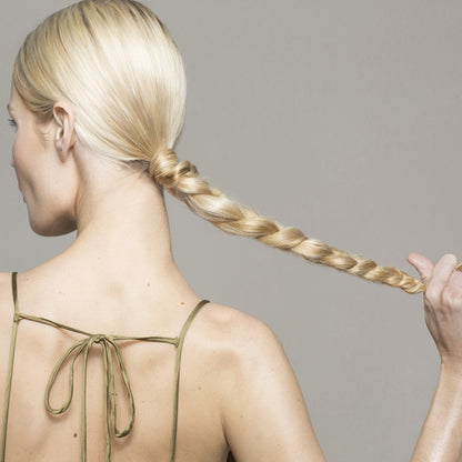 Women facing sideways with a long silky blonde hair braid