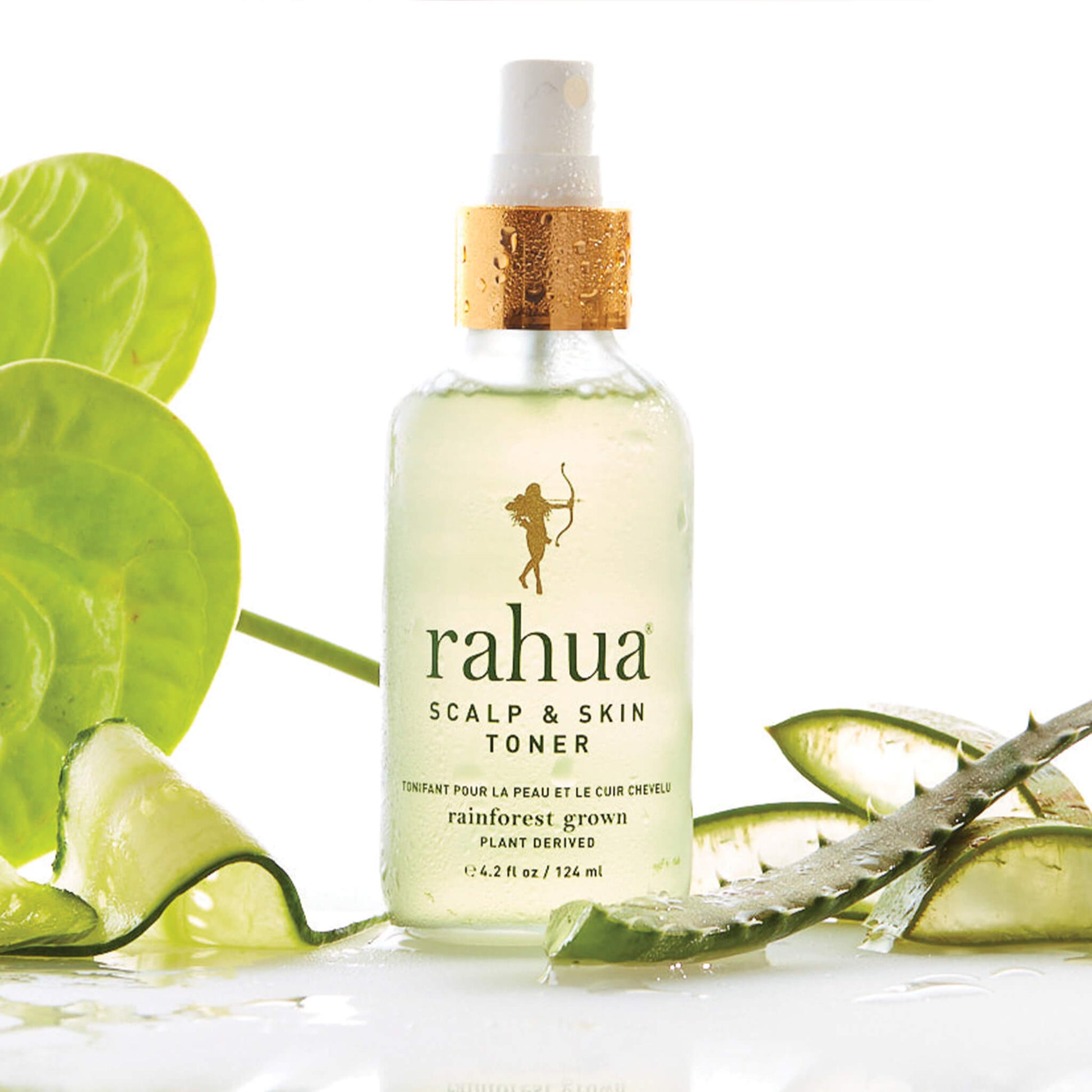 glass spray bottle with gold collar and green text rahua scalp and skin toner on a plain white background with slices of cucumber and aloe vera|variant:1-oz